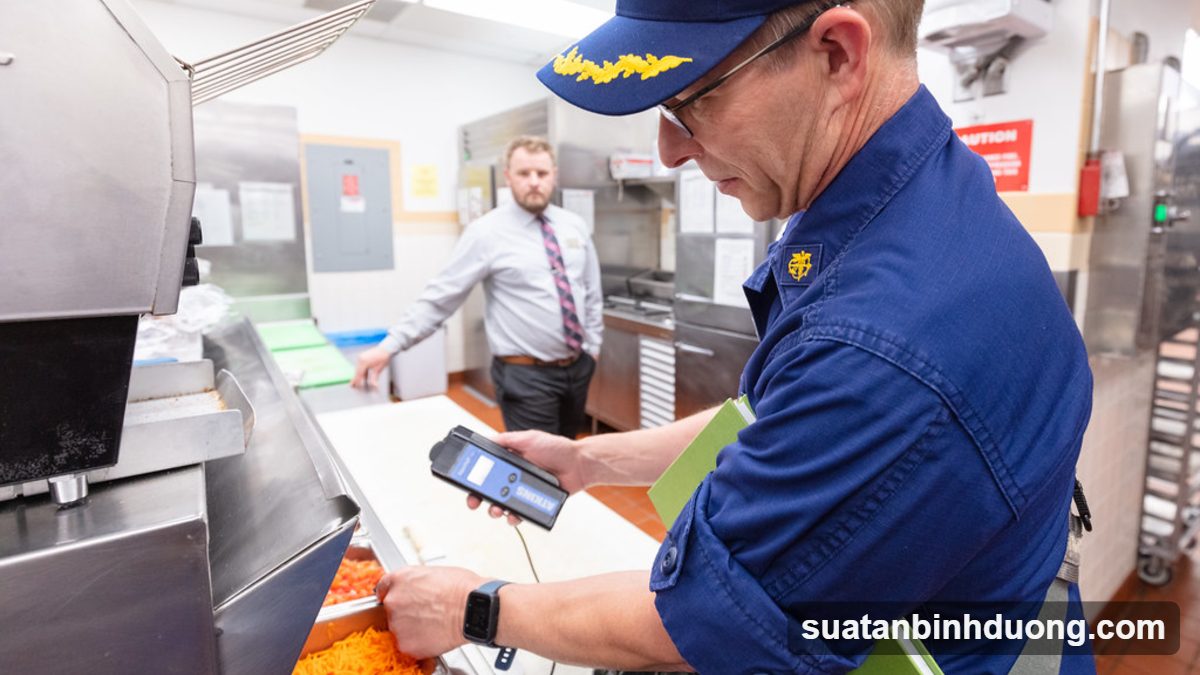 Đầu bếp đeo găng tay, mũ trùm khi chế biến suất ăn – Bình Dương Catering